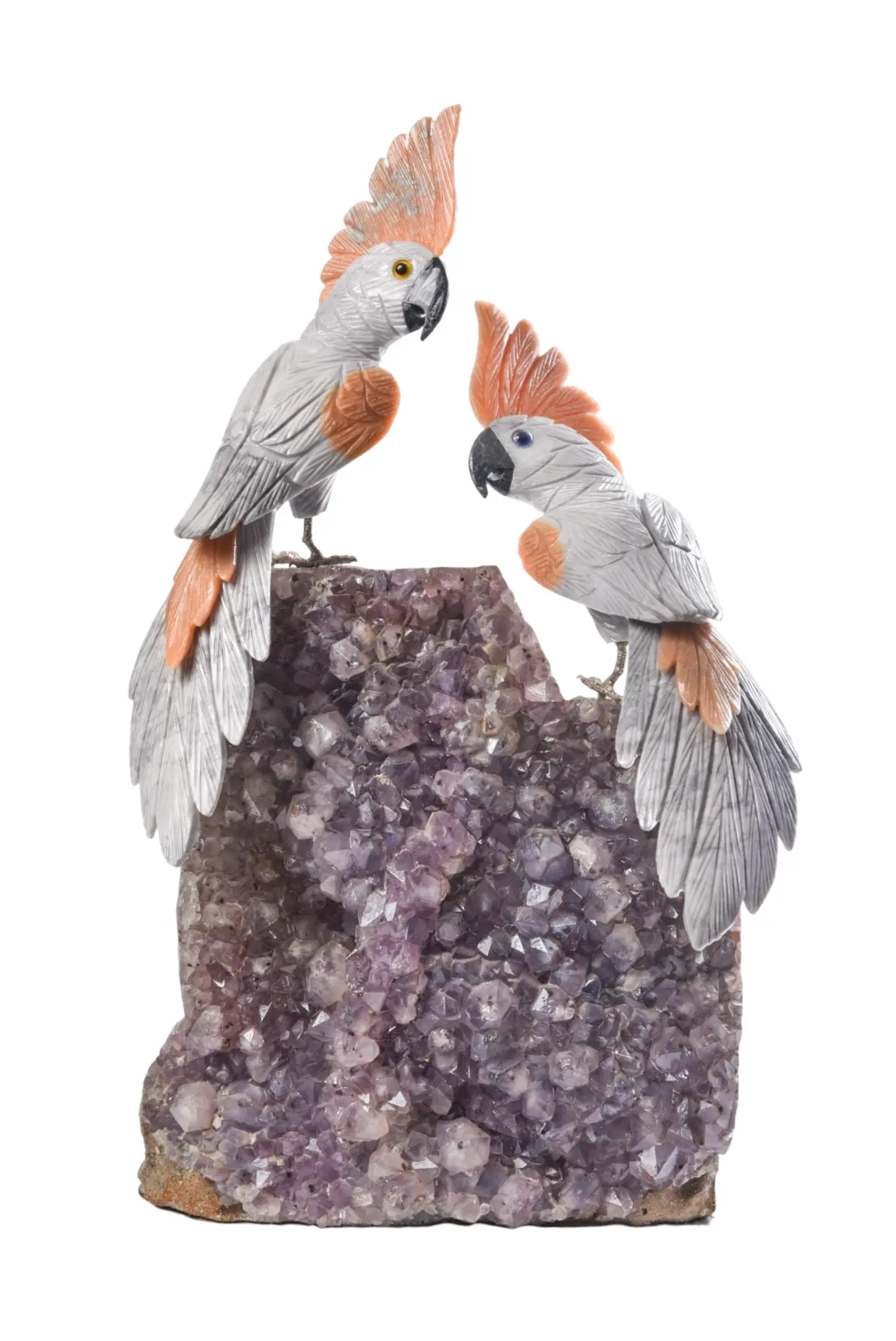 Pair of cockatoos carved in grey and coral stone on an amethyst druse