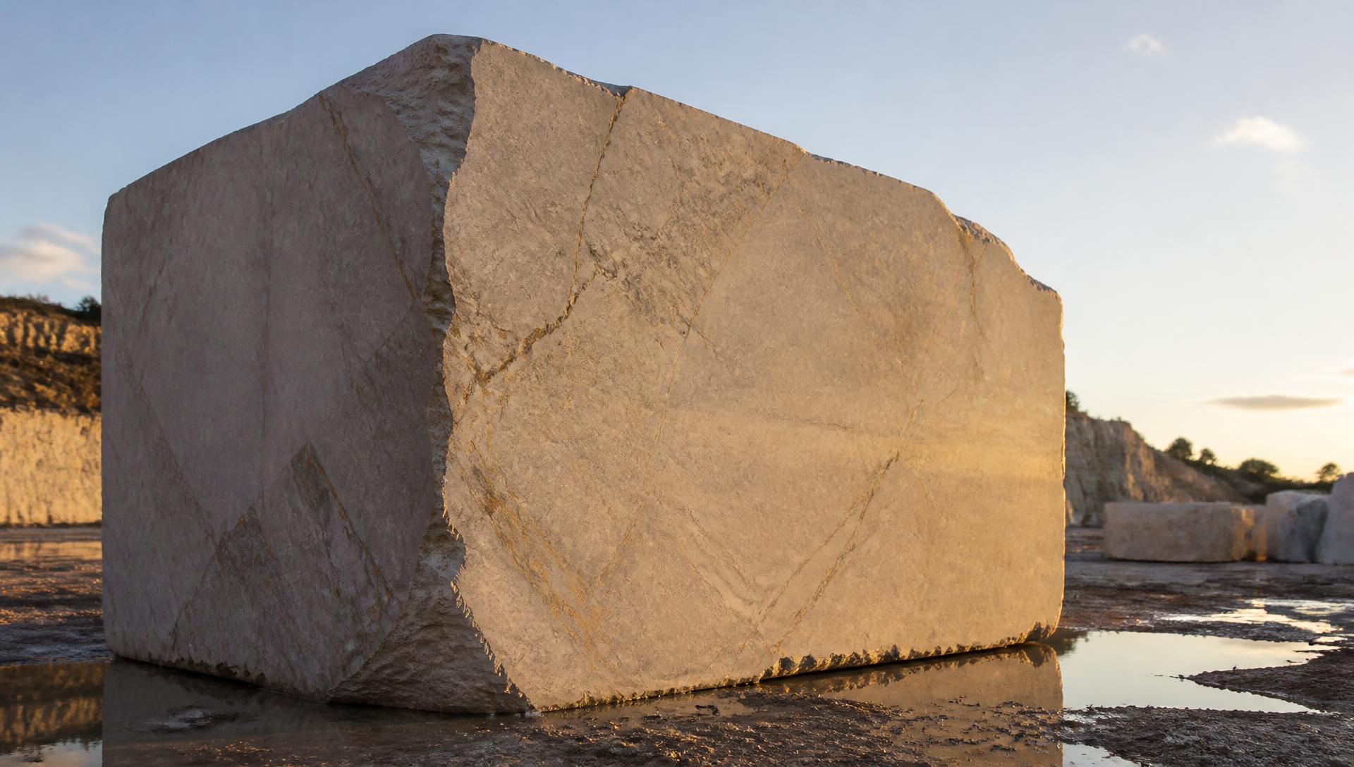 Monumental block of natural stone in a yard at dusk